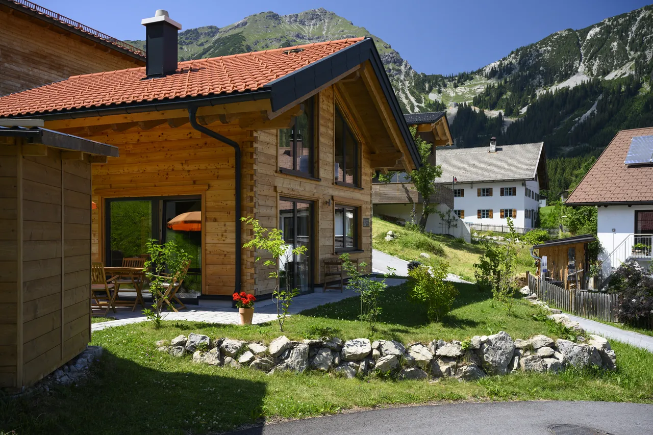 Holzhaus 171 im Hochsommer vor der Bergkulisse der Lechtaler Alpen